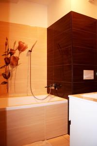 a bathroom with a shower with flowers on the wall at Hotel Herman in Rychnov nad Kněžnou