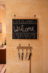 a sign on a wall with the words welcome at Ta' Klementa Farmhouse in Għarb