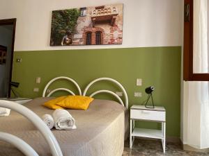 um quarto com uma cama e uma parede verde em All'Arena em Verona