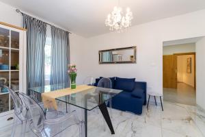 a living room with a glass table and a blue couch at LA MARLENA in Benkovac