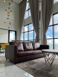 uma sala de estar com um sofá castanho e uma mesa em Peak Manor Penthouse at Genting Highlands near Sky Avenue em Genting Highlands