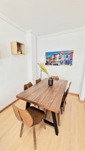 una mesa de comedor de madera con sillas en una habitación en Apartamento ZONA en Albacete