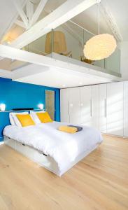 ein Schlafzimmer mit einem großen weißen Bett mit gelben Kissen in der Unterkunft Le Filatiers - incroyable loft aux Carmes in Toulouse