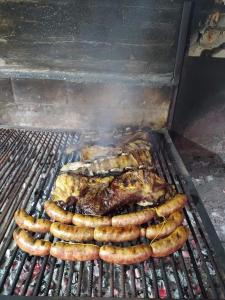 un grupo de salchichas y carne en una parrilla en Quinta Los Cardales en Los Cardales