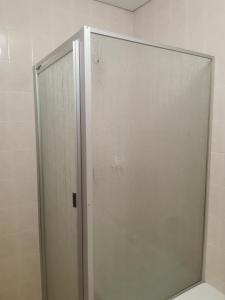 La salle de bains est pourvue d'une cabine de douche avec une porte en verre. dans l'établissement Rose Guest House, à Pretoria