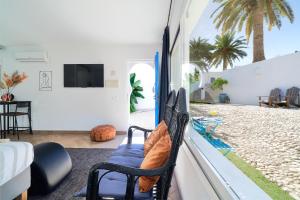 a room with a balcony with a chair and a tv at Mauresque Experience Luxury in Torremolinos