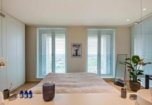 een slaapkamer met een groot bed en ramen bij Sky loft - Luxurious Penthouse - Antwerp 180 m² in Antwerpen