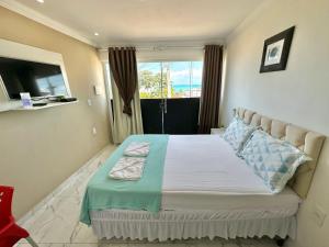a bedroom with a large bed with a window at Pousada Maresia in Maragogi