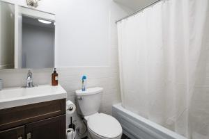 uma casa de banho com um WC, um lavatório e um chuveiro em Apartment 227: Upper West Side em Nova York