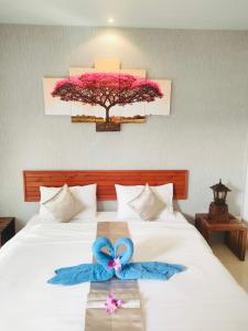 a bedroom with a bed with two blue bows on it at Andawa Lanta Resort in Ko Lanta