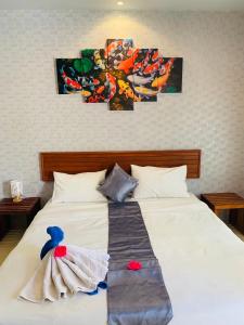 a bedroom with a white bed with paintings on the wall at Andawa Lanta Resort in Ko Lanta