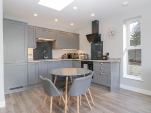 a kitchen with a table and chairs in a kitchen at Aneths Annex in Drybrook