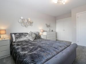una camera da letto con un letto con un piumone bianco e nero di Aneths Annex a Drybrook