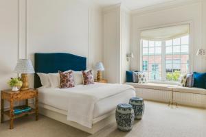 a white bedroom with a bed and a window at Gardiner House in Newport