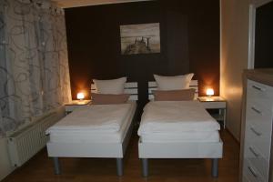 two twin beds in a room with two candles at Apartment Messezimmer Flughafen Köln Bonn in Rösrath