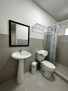 een badkamer met een wastafel, een toilet en een spiegel bij Sunset Catalina in Santa Catalina