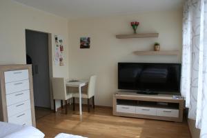 a living room with a television and a table with chairs at Apartment Messezimmer Flughafen Köln Bonn in Rösrath