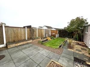 a backyard with a wooden fence and a yard at Tranquil 3-bedroom bungalow 