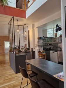 a large kitchen with a table and chairs in it at Loft en duplex 270 m2 & Jardin patio terrasse sauna in Chaville