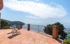 une chaise assise sur un balcon donnant sur l'eau dans l'établissement Villa la Malpagne, 400m2 les pieds dans l'eau, à Rayol-Canadel-sur-Mer