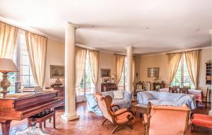a living room with a couch and a piano at Villa la Malpagne, 400m2 les pieds dans l'eau in Rayol-Canadel-sur-Mer