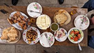 une table en bois avec des assiettes de nourriture dans l'établissement Shin•შინ, à Koutaïssi
