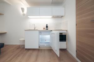 a small kitchen with white cabinets and a sink at Le petit bellifontain in Fontainebleau