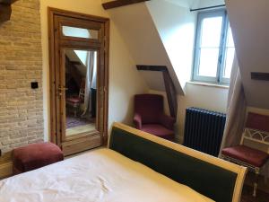 a bedroom with a bed and two chairs and a window at CLOS DU BAILLI in Saint-Omer