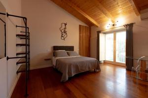 een slaapkamer met een bed en een houten vloer bij Favolosa residenza con jacuzzi in Santa Maria Capua Vetere