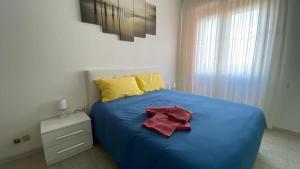 een slaapkamer met een blauw bed met een handdoek erop bij Saronno 800 mt dalla stazione in Saronno