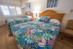 um quarto com 2 camas e uma cadeira em New Remodeled Direct Oceanfront Views @ Beach Cove em Myrtle Beach