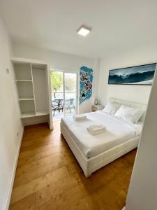 um quarto com uma grande cama branca e uma mesa em Oeiras Beach guest house em Oeiras