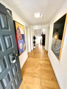 a hallway with paintings on the walls and a door at Oeiras Beach guest house in Oeiras