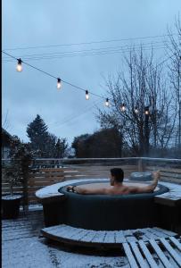 a man sitting in a bath tub in the snow at Chata Fraluq in Tatobity