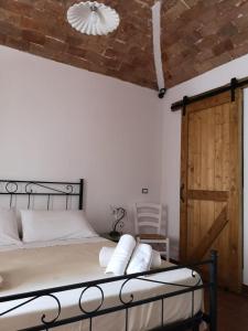 Schlafzimmer mit einem Bett und einer Holztür in der Unterkunft ficodindia Suite & Apartments in Santo Stefano di Camastra