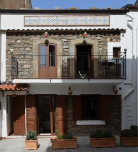 un edificio con balcone e tavolo sopra di ficodindia Suite & Apartments a Santo Stefano di Camastra