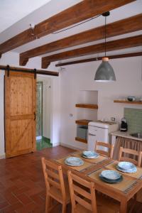 ein Esszimmer mit einem Tisch und Stühlen sowie eine Küche in der Unterkunft ficodindia Suite & Apartments in Santo Stefano di Camastra