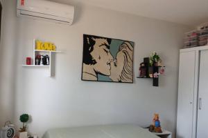 マリンガにあるChácara Horientalのベッドルーム1室(ベッド1台付)が備わります。壁に絵が飾られています。