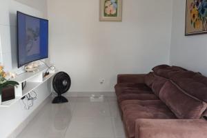 uma sala de estar com um sofá castanho num quarto em Chácara Horiental em Maringá