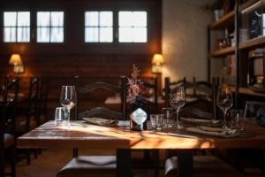 a wooden table with glasses and a vase of flowers on it at Motel-Restaurant 13 Etoiles in Saint-Léonard