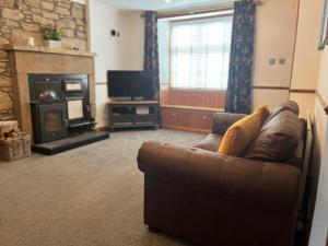 a living room with a couch and a fireplace at 2 Swinton Mill Farm Cottage in Swinton