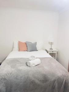 a bedroom with a white bed with a towel on it at Family Room close in Bristol