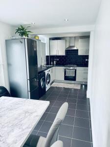 a kitchen with a stainless steel refrigerator and a table at Family Room close in Bristol