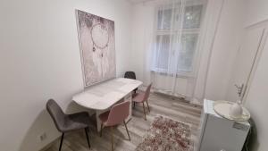 a white table and chairs in a room with a window at Apartman Centrum Mudronova in Košice