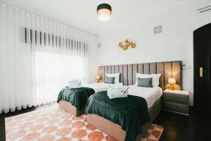 a hotel room with two beds and a window at Aparthotel QuintadaCostinha Alijó Douro in Alijó