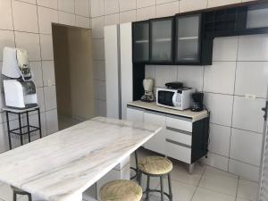 a kitchen with a table with stools and a microwave at Casa de Praia - Carneiros, Tamandare, Pernambuco in Tamandaré