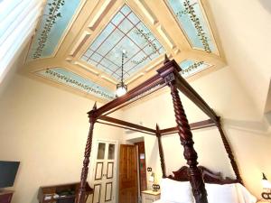 a bedroom with a canopy bed with a ceiling at Hotel Boutique Conde de la Corte in Zafra