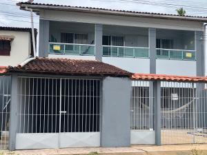 a white house with two gates and a balcony at Casa de Praia - Carneiros, Tamandare, Pernambuco in Tamandaré