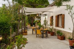 une terrasse avec une table, des chaises et des plantes dans l'établissement Casa Vacanze Lachesi, à Caccamo