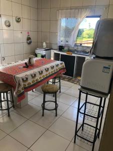 a kitchen with a table and two chairs and a stove at Casa de Praia - Carneiros, Tamandare, Pernambuco in Tamandaré